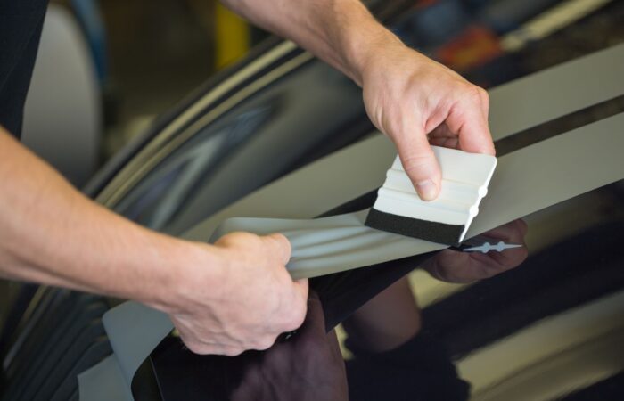 Car,Wrapper,Straightening,Wrapping,Foil,With,A,Squeegee,To,Remove